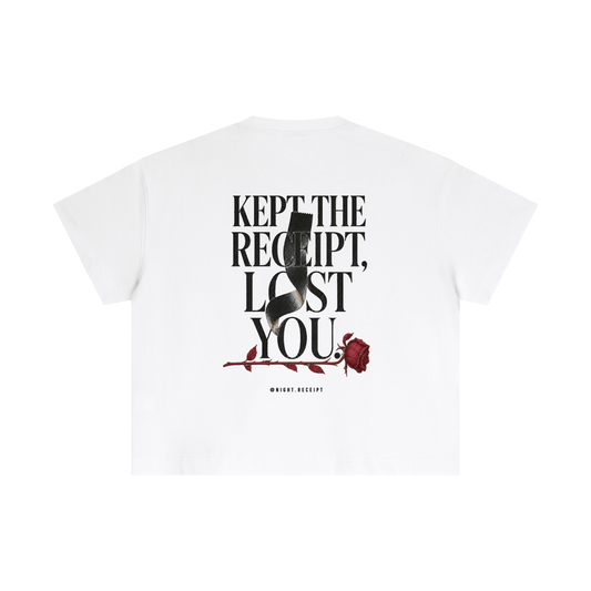 Back of the white Night Receipt boxy cotton tee with KEPT THE RECEIPT, LOST YOU in editorial serif capitals and a blank thermal receipt threading through the type and wilting into an oxblood rose