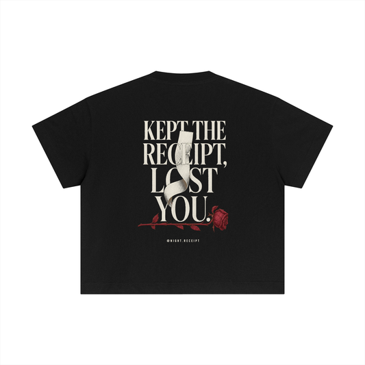 Back of the black Night Receipt boxy cotton tee with KEPT THE RECEIPT, LOST YOU in editorial serif capitals and a blank thermal receipt threading through the type and wilting into an oxblood rose