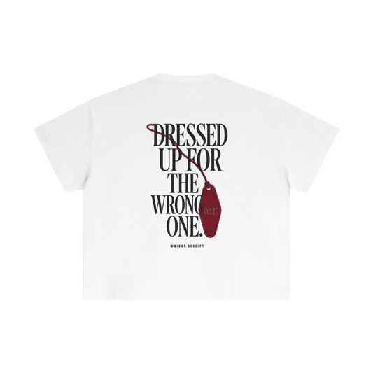 Back of the white Night Receipt boxy cotton tee with DRESSED UP FOR THE WRONG ONE in editorial serif capitals and an unbranded oxblood hotel key tag stamped 02:17 hanging off the type
