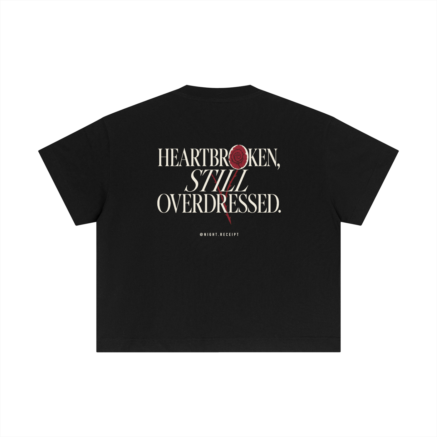 Back of the black Night Receipt boxy cotton tee with HEARTBROKEN, STILL OVERDRESSED in editorial serif capitals and a pressed oxblood rose blooming through the letterform