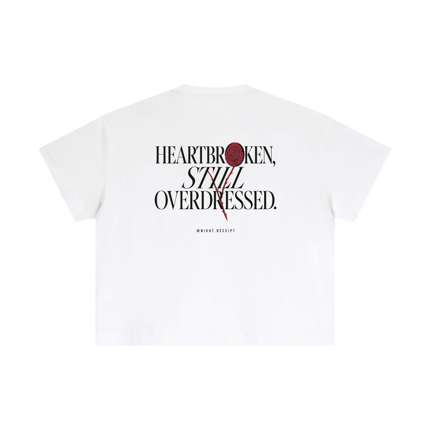 Back of the white Night Receipt boxy cotton tee with HEARTBROKEN, STILL OVERDRESSED in editorial serif capitals and a pressed oxblood rose blooming through the letterform