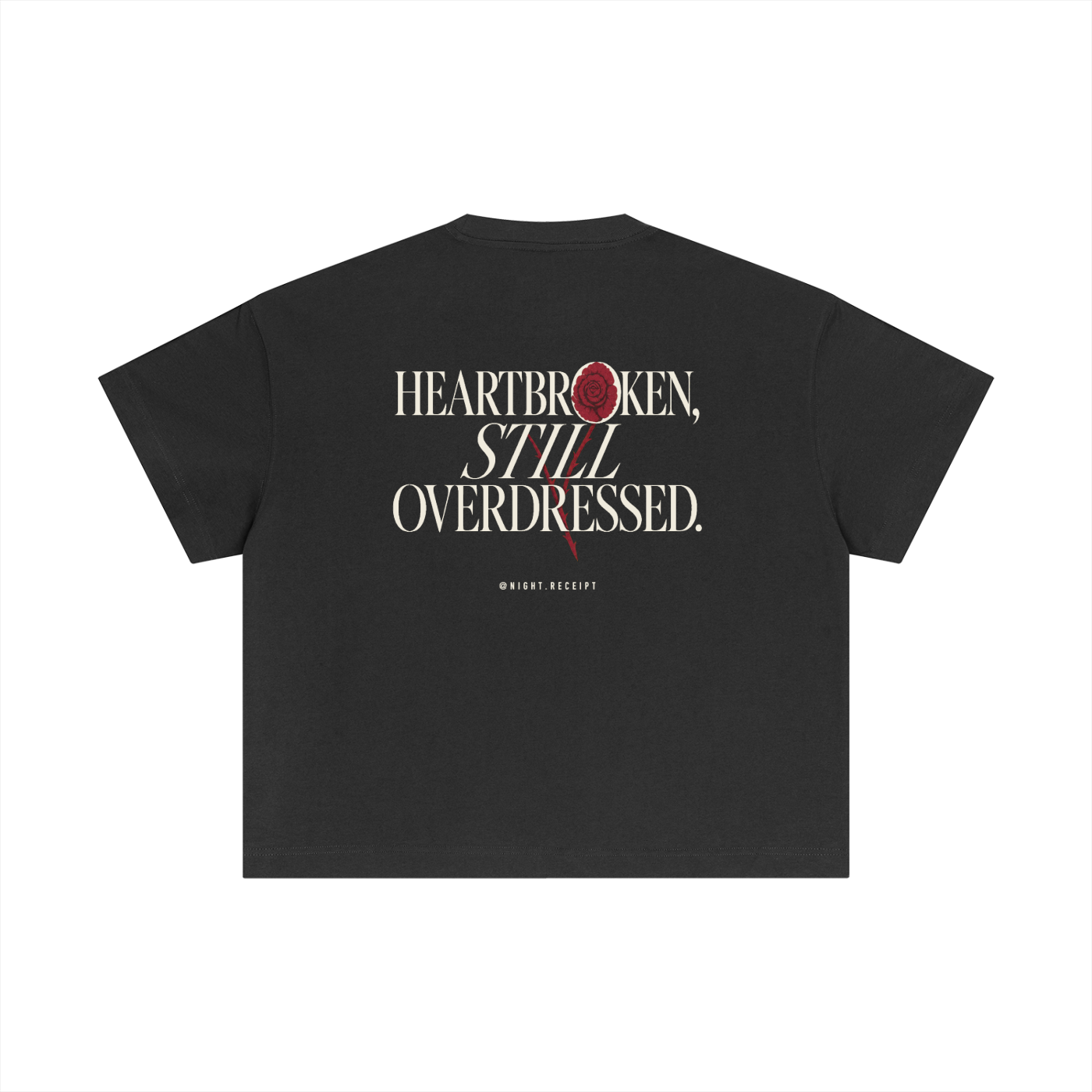Back of the dark gray Night Receipt boxy cotton tee with HEARTBROKEN, STILL OVERDRESSED in editorial serif capitals and a pressed oxblood rose blooming through the letterform