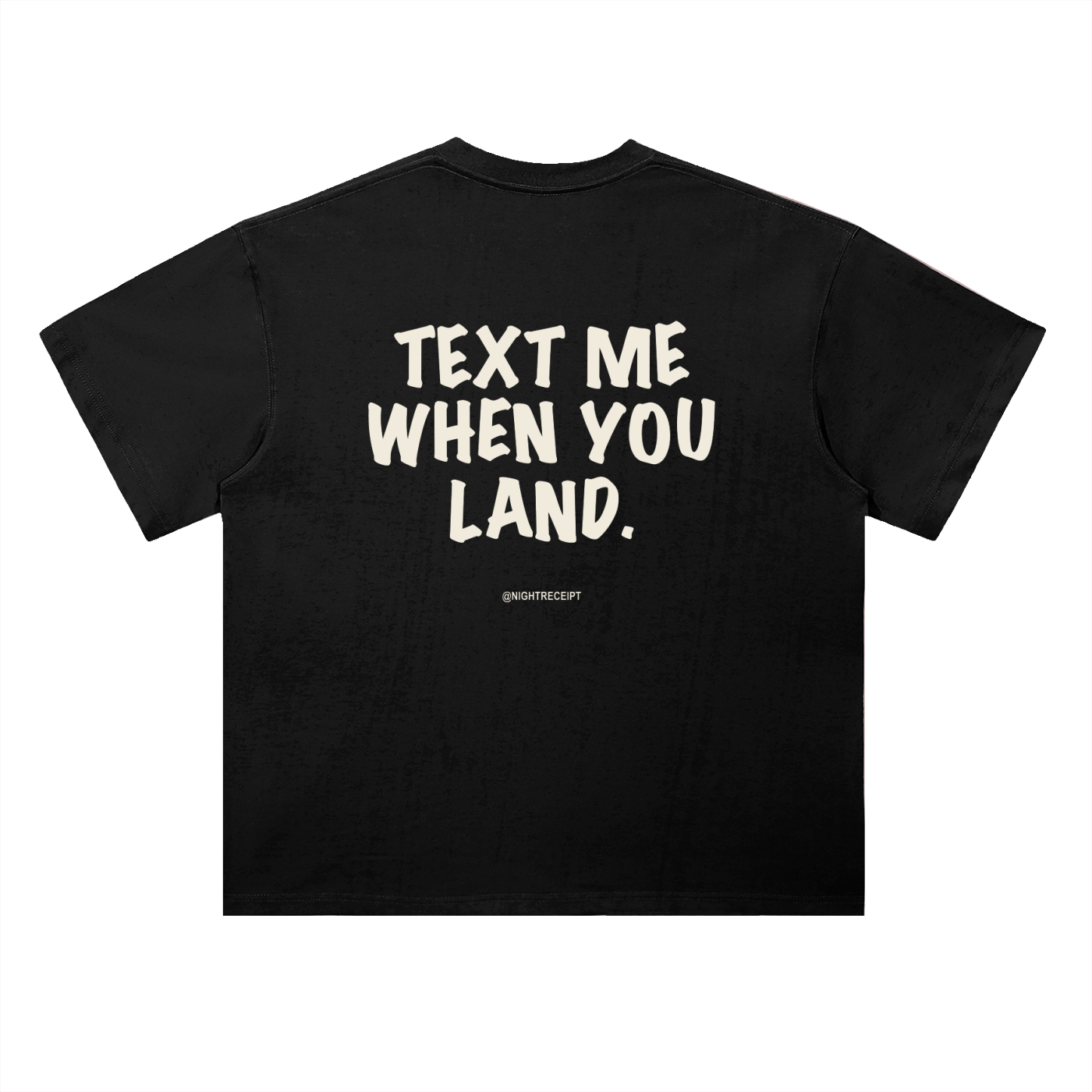 Back of the black heavyweight drop-shoulder tee with TEXT ME WHEN YOU LAND printed large in cream marker lettering