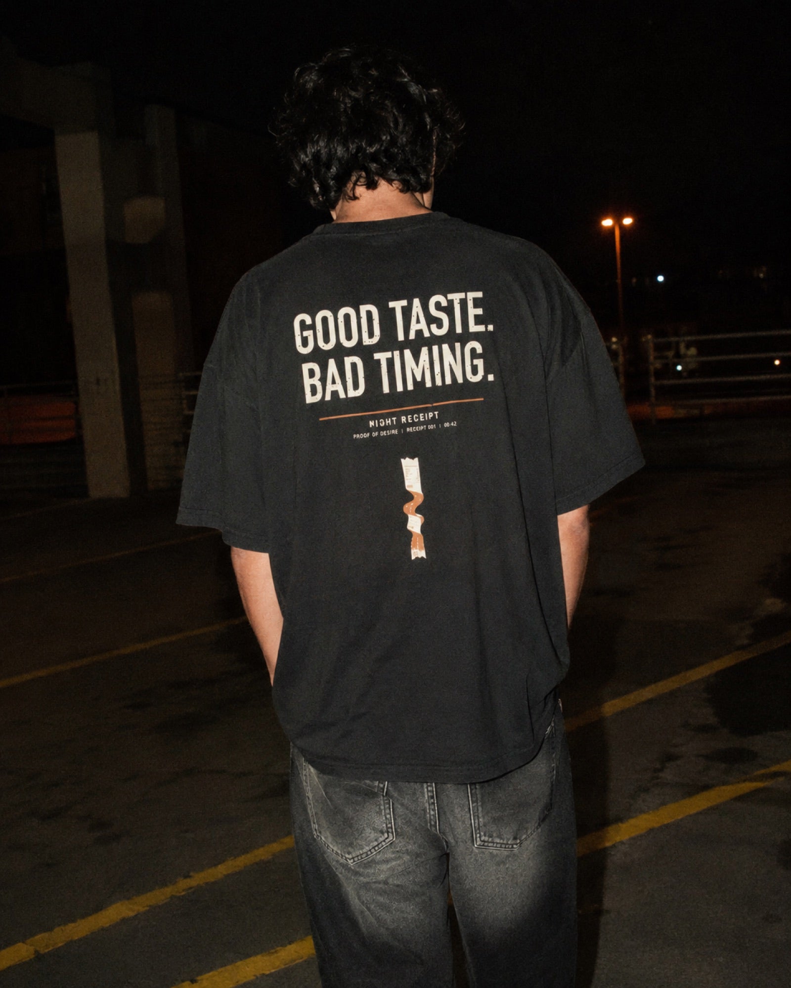 Night Receipt heavyweight tee, back print photographed at night with direct flash